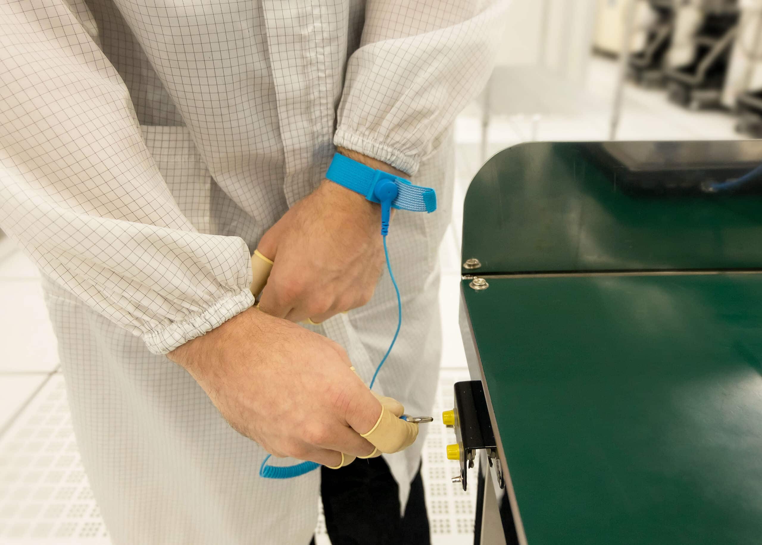 Operative inserting ESD grounding cord into an underbench bonding point - Bondline