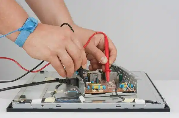 Man with Antistatic Wrist Straps repairing LCD Monitor